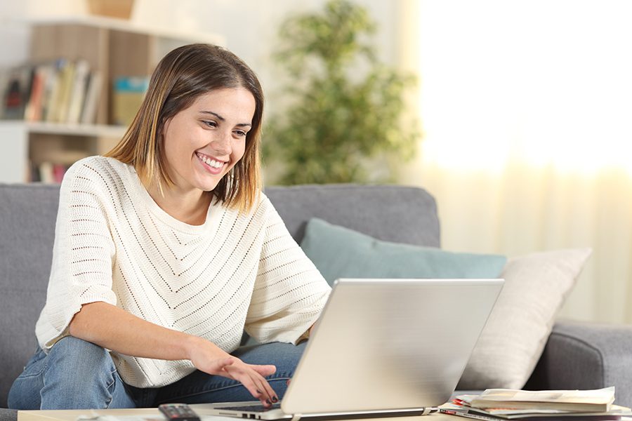 Monitor Your Credit Score - Happy Woman Checking Her Credit Score on Her Laptop at Home